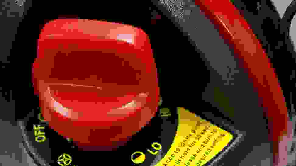 Close-up on a garage heater, operated by a large red knob.