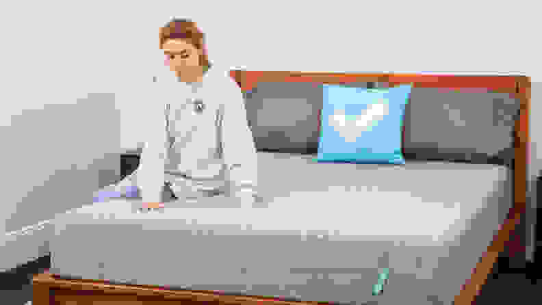 A person sitting on the Siena Memory Foam mattress.